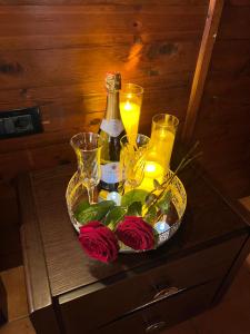 uma bandeja com uma garrafa de vinho, rosas e velas em Deluxe Hotel em Berat