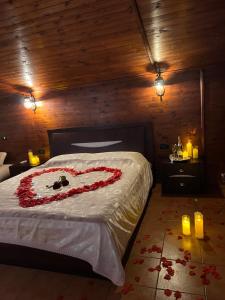 Una cama con un corazón hecho de rosas en Deluxe Hotel, en Berat