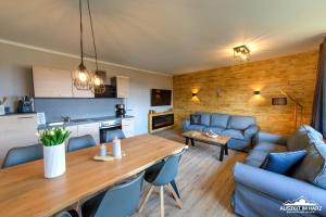 eine Küche und ein Wohnzimmer mit einem Tisch und einem Sofa in der Unterkunft Auszeit im Harz Haus 3 Wohnung 6 in Braunlage
