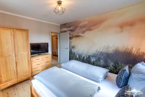 a bedroom with two beds and a painting on the wall at Auszeit im Harz Haus 3 Wohnung 6 in Braunlage