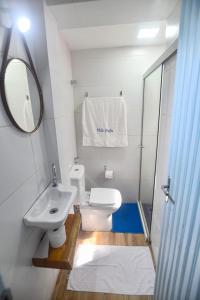 La salle de bains est pourvue de toilettes, d'un lavabo et d'un miroir. dans l'établissement Vila DuJu, à Porto de Galinhas
