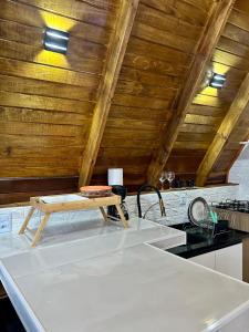 una cocina con techos de madera y una mesa en una encimera en Refúgio de Gaia, en Chapecó