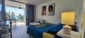 - une chambre avec un lit et une table avec une lampe dans l'établissement Turquoise studio remarquable vue mer, au Diamant