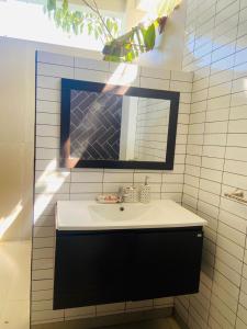 a bathroom with a sink and a mirror at Pacifico El Paredon in El Paredón Buena Vista