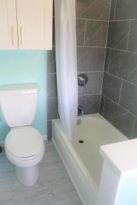 a bathroom with a toilet and a tub and a sink at Hawaiian Monarch 1611 condo in Honolulu