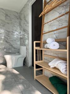 a bathroom with a toilet and towels at Spiral Resort in Ko Phayam