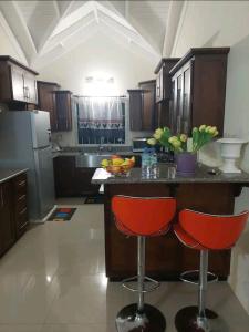 a kitchen with two red bar stools and a counter at Royal Palm Luxury Villas in Ocho Rios