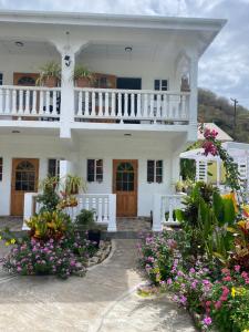 una casa blanca con flores delante en Cool Breeze Suites, en Union Island