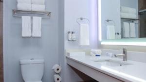 La salle de bains blanche est pourvue de toilettes et d'un lavabo. dans l'établissement Holiday Inn Express & Suites - Ciudad Obregon, an IHG Hotel, à Ciudad Obregón