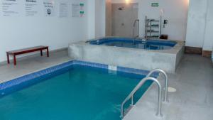 uma grande piscina com uma banheira num quarto em Holiday Inn Express & Suites - Ciudad Obregon, an IHG Hotel em Ciudad Obregón