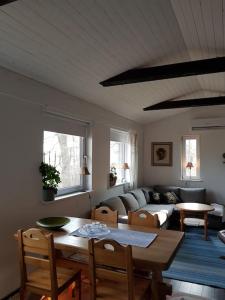 sala de estar con mesa y sofá en Ekbacken - naturskön stuga med närhet till havet en Nyköping