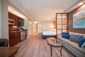 een woonkamer met een bank en een kamer met een bed bij No Resort Fee Strip View Suite +Free Valet + Pool in Las Vegas