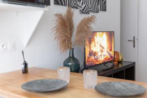 2 platos en una mesa con TV en una habitación en Le Zen - Proche Paris et Aéroport d'Orly, en Alfortville