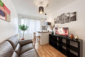 sala de estar con sofá y cocina con mesa en Le Zen - Proche Paris et Aéroport d'Orly, en Alfortville