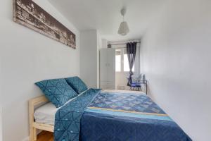 1 dormitorio con 1 cama con edredón azul en Le Zen - Proche Paris et Aéroport d'Orly, en Alfortville