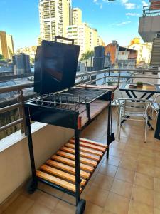 a grill on top of a balcony with a table at Paramont Tucuman in San Miguel de Tucumán
