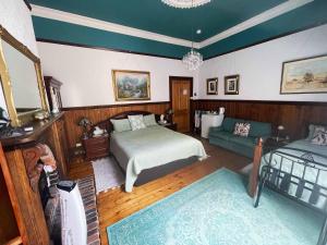 a bedroom with a bed and a couch at Stony Rise Cottage B&B in Devonport