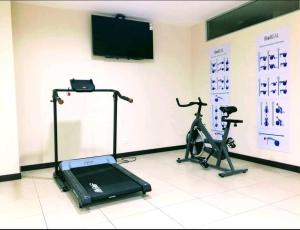 a room with a gym with a treadmill and a tv at Suite bussines half of the world 12 in Quito