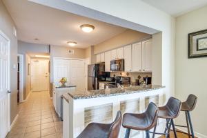 eine Küche mit einer Bar mit Hockern in der Unterkunft Charming Gulfport Condo - Walk to Beach Access! in Gulfport