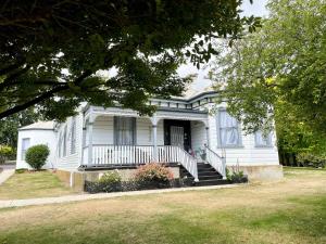 a white house with a porch and stairs to it at Stony Rise Cottage B&B in Devonport