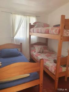 a bedroom with two bunk beds and a window at Casa Quelita in Punta de Choros