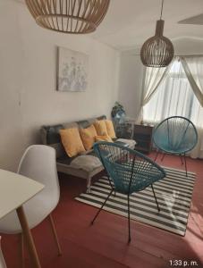 sala de estar con sofá y 2 sillas en Casa Quelita, en Punta de Choros
