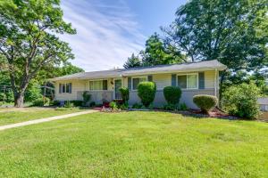 a small yellow house with a grass yard at District Heights Apartment with Patio and Seating in District Heights