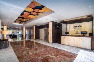 eine Lobby mit einer Rezeption in einem Gebäude in der Unterkunft Barceló Murcia Siete Coronas in Murcia