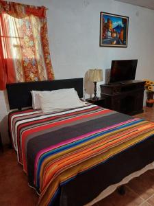 a bedroom with a bed and a desk with a laptop at Santa Gertrudis in El Rancho