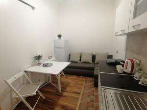 eine Küche mit einem Tisch und einer Couch in einem Zimmer in der Unterkunft Tsar Dušan Apartment in Belgrad