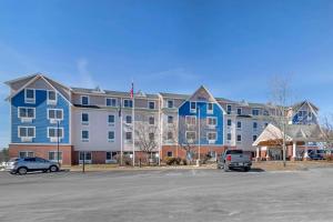 a large building with a car parked in a parking lot at Comfort Inn & Suites Dover-Portsmouth in Dover