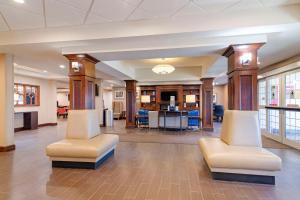 a lobby with two white chairs and a table at Comfort Inn & Suites Dover-Portsmouth in Dover