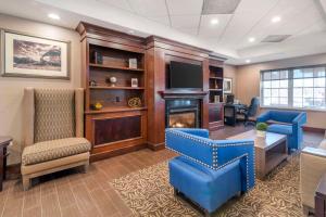 an office with a fireplace and a desk and chairs at Comfort Inn & Suites Dover-Portsmouth in Dover