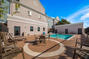 a patio with chairs and a pool in a building at Comfort Suites in Bastrop