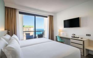 a hotel room with a bed and a large window at Occidental Fuengirola in Fuengirola