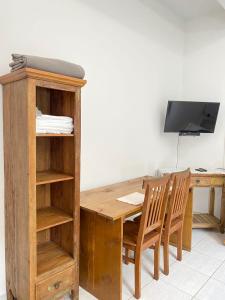 a wooden desk with two chairs and a television at CHALÉ da LÚ ILHABELA in Ilhabela