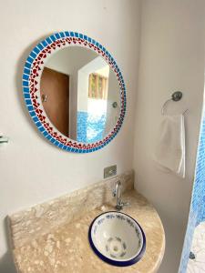 a bathroom with a sink and a mirror at CHALÉ da LÚ ILHABELA in Ilhabela