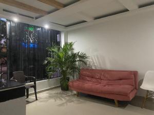 ein Wohnzimmer mit einer roten Couch und einer Pflanze in der Unterkunft HOTEL IBIZA in Valledupar