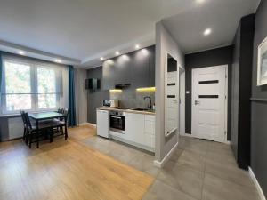 a kitchen with white cabinets and a table at Centrum Apartment na Zamenhofa in Białystok