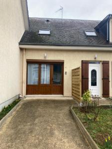 a house with a wooden door and a driveway at Appartement dans une maison cosy in Chartres