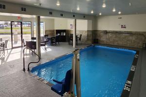 a large swimming pool in a building with a restaurant at Sleep Inn Olathe - Kansas City in Olathe