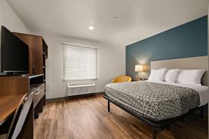 una camera da letto con un letto e una TV a schermo piatto di WoodSpring Suites Port Orange - Daytona Beach a Port Orange