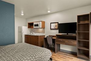 Habitación de hotel con cama y escritorio con ordenador en WoodSpring Suites Port Orange - Daytona Beach, en Port Orange