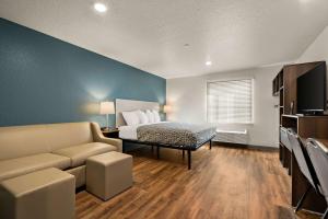 a bedroom with a bed and a couch in a room at WoodSpring Suites Port Orange - Daytona Beach in Port Orange