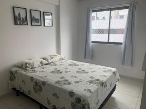 Cama en habitación blanca con ventana en Apartamento Moderno e Tranquilo, en Recife