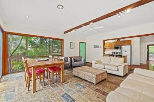 a living room with a table and a couch at Leafy Family House, Close to Beach and Surf Club in Macmasters Beach