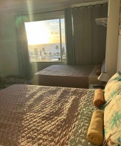 twee bedden in een kamer met uitzicht op de oceaan bij Pousada do mirante in Cabo de Santo Agostinho