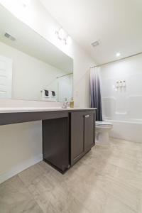 a bathroom with a sink and a mirror and a toilet at Modern Oasis in Beulah Village