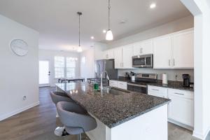 a kitchen with white cabinets and a granite counter top at Modern Oasis in Beulah Village