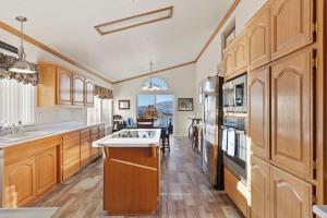 uma cozinha com armários de madeira e um frigorífico em Brite Vista Retreat em Tehachapi